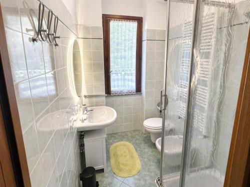 a bathroom with a sink and a toilet and a shower at The Terrace Overlooking Lake Como in Muronico