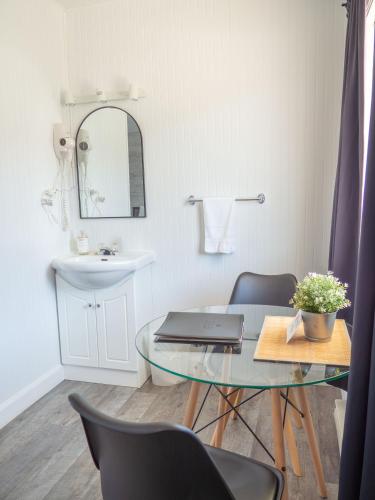 a bathroom with a table with a laptop on it at Maison LeBreux - Motel in Petite-Vallée