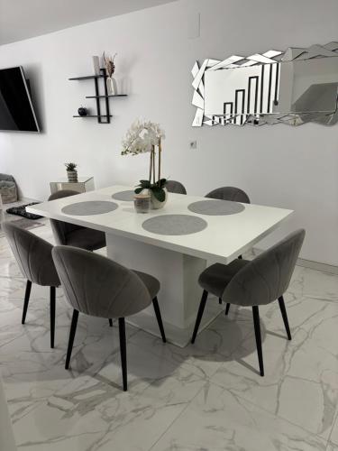 a dining room with a white table and chairs at Le 21 Comfortable townhouse in Morhange