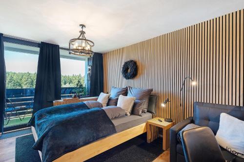 a bedroom with a bed and a couch and a window at Forest Elegance in Freudenstadt
