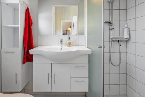 a white bathroom with a sink and a shower at FY417-Assens-Glentevej-8 in Næs