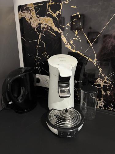 a white coffee maker sitting on top of a counter at Le 21 Comfortable townhouse in Morhange