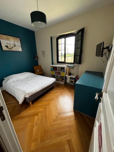 a bedroom with a bed and a blue wall at Apartment with terrace Mérignac in Mérignac
