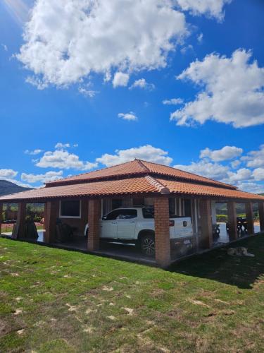 a carport with a car parked in a house at Solar do Ouro in São Thomé das Letras
