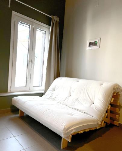 a bed in the corner of a room with a window at Iriki Loft, ένας ατμοσφαιρικός ρετρό χώρος στην Μυτιλήνη in Mytilene