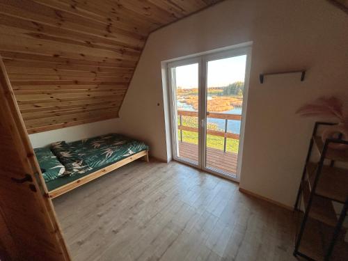 a room with a bed and a large window at Dom Pod Niebem in Świętajno