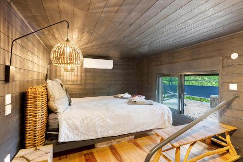 a bedroom with a bed and a wooden wall at Cabane Spa-Truffiers-Proche Sarlat in Jayac