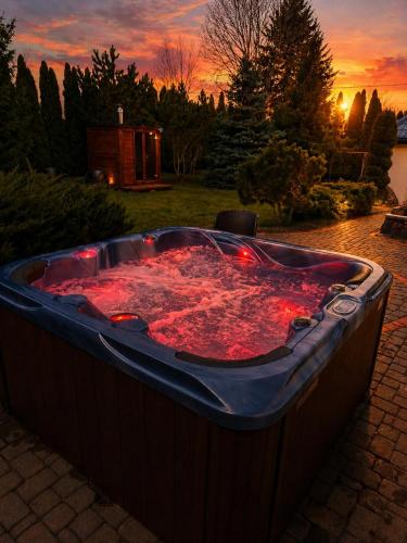 a large hot tub sitting on a patio at sunset at Ostoja Tobołowo in Tobołowo