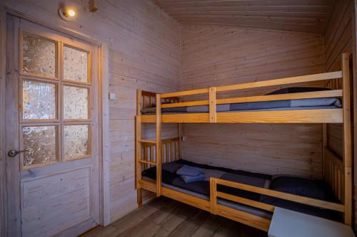 a bedroom with bunk beds in a log cabin at Domki Między Wodami in Kołczewo