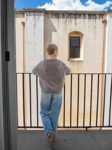 a man looking out a window at a building at Palazzo Vaglio in Alliste