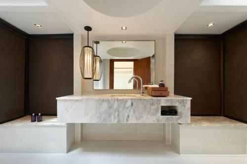a bathroom with a marble sink and a mirror at Centara Villas Phuket in Karon Beach