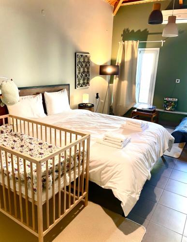a bedroom with a large bed with a crib at Iriki Loft, ένας ατμοσφαιρικός ρετρό χώρος στην Μυτιλήνη in Mytilene