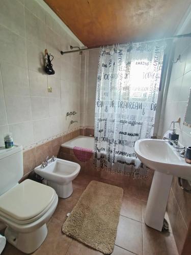 a bathroom with a toilet and a sink and a tub at Mountain, espectacular departamento con vista súper funcional in Ushuaia