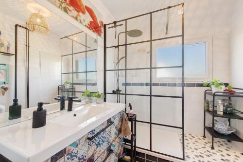 a bathroom with a sink and a glass wall at Chez Fred proche plage et gr34 in Plougoulm