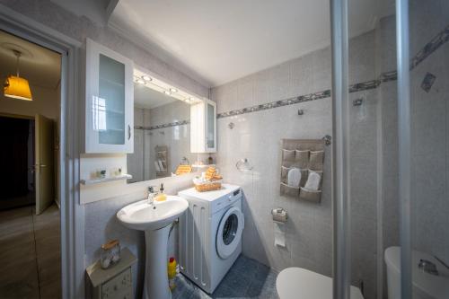 a bathroom with a washing machine and a sink at Miranta's Studios in Mytilene