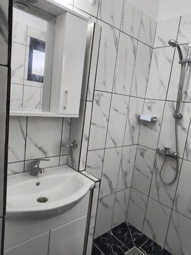 a white bathroom with a sink and a mirror at Casa Dorului in Mangalia