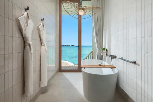 a bathroom with a tub and a view of the ocean at Centara Grand Lagoon Maldives - Free Round Trip Speedboat when stay 4 nights or more between 17 April - 15 October 2026 in North Male Atoll