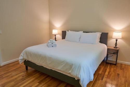 a bedroom with a large white bed with two lamps at Cozy Huguenot Hideaway in Huguenot