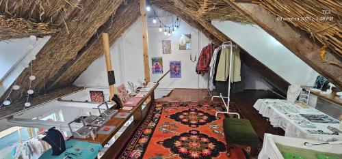an attic room with tables and a rug on the floor at Corps-A in Almaty