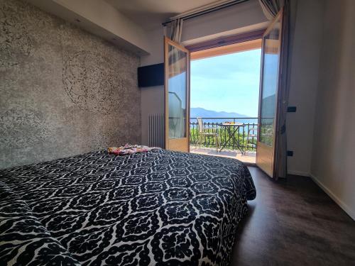 a bedroom with a bed with a view of a balcony at Albergo Suisse Bellevue in Monterosso al Mare