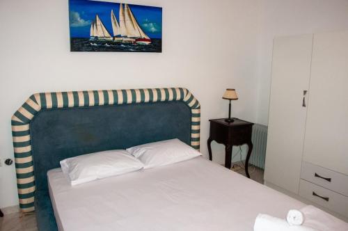 a bedroom with a bed with a sailboat picture on the wall at Arcadia Coastal Studio by ΜΡS in Xiropigado
