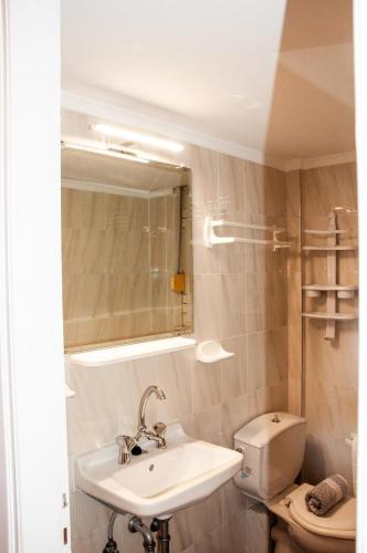 a bathroom with a sink and a toilet and a mirror at Arcadia Coastal Studio by ΜΡS in Xiropigado