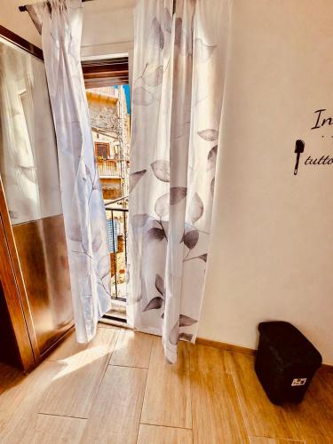a room with a door and a window with curtains at Mediterranea Apartment in Agrigento