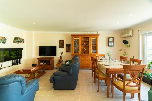 a living room with a table and a dining room at Family Comfort House in Seixal