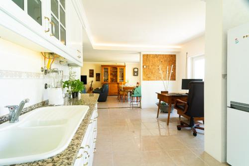 a kitchen and living room with a sink and a desk at Family Comfort House in Seixal