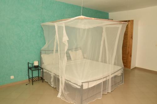 a bed with a canopy in a room at Villa Saraba in Somone
