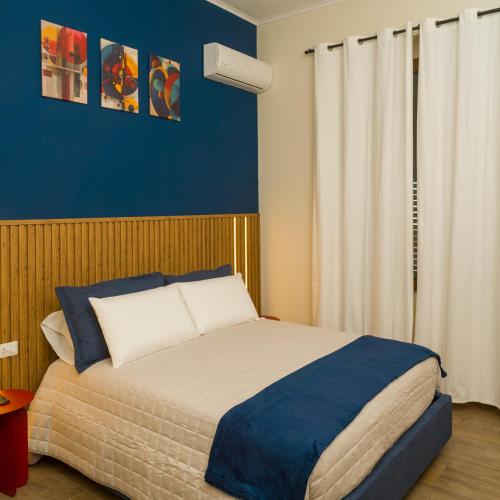 a bedroom with a bed and a blue wall at Prima Classe Battipaglia in Battipaglia