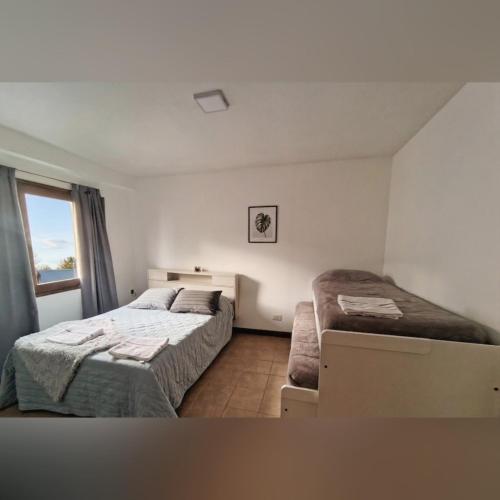 a bedroom with two beds and a window at Mountain, espectacular departamento con vista súper funcional in Ushuaia