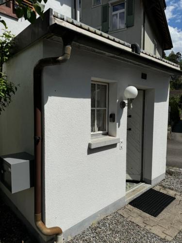 a white building with a window and a door at Garden House Interlaken in Interlaken