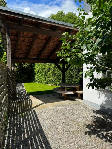 a wooden shelter with a picnic table in a garden at Garden House Interlaken in Interlaken