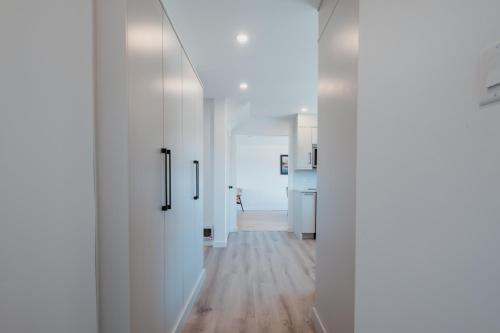 a hallway with white walls and wooden floors at Cherry Lane Cottage | 3 Bed & 2 Bath in Foxtrap