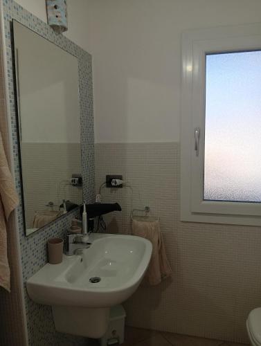 a bathroom with a sink and a mirror at Little paradise apartment with pool in Orosei