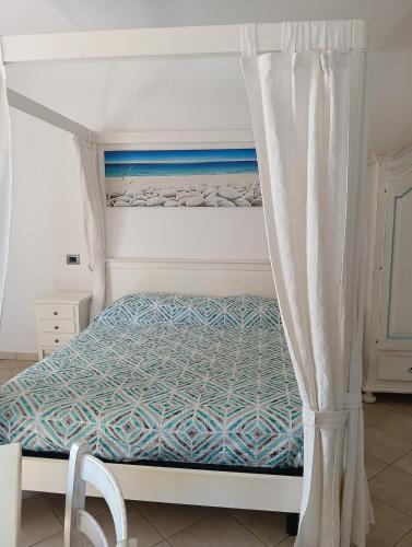 a bedroom with a bed with a canopy at Little paradise apartment with pool in Orosei