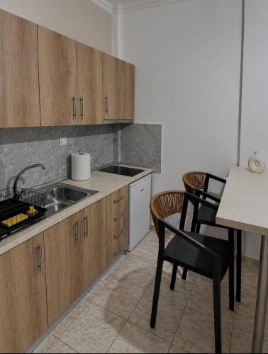 a kitchen with wooden cabinets and a sink and chairs at Diktamo Coast Living in Ofrínion