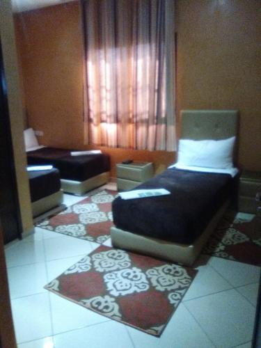 a small room with a bed and a couch at Hotel Rimal Sahara in Laayoune