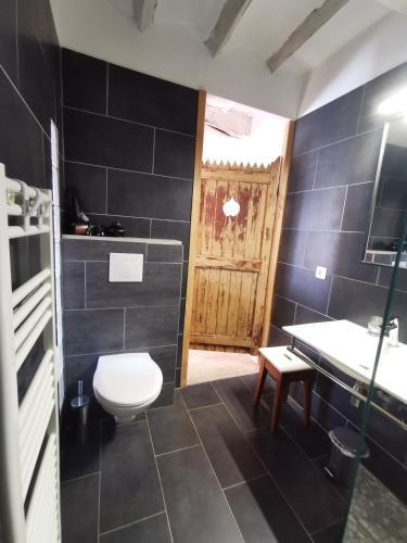 a bathroom with a white toilet and a sink at Gîtes Chambres d'hôtes de charme B&B - La Cense du Pont - Campagne de Lille in Bachy