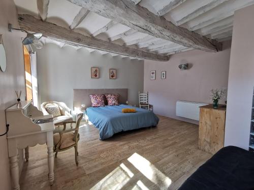 a bedroom with a bed and a desk and a piano at Gîtes Chambres d'hôtes de charme B&B - La Cense du Pont - Campagne de Lille in Bachy