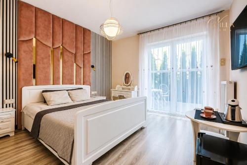 a bedroom with a bed and a large window at Villa Lima in Ustka