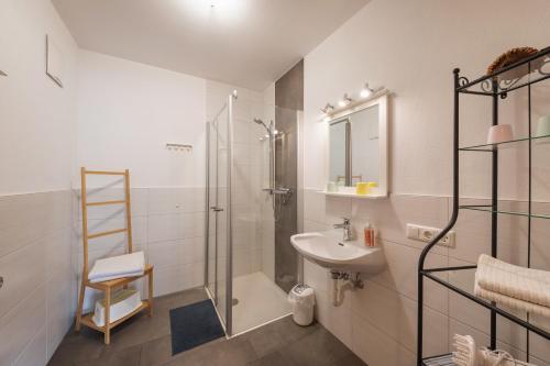 a white bathroom with a shower and a sink at Haus am Bach in Fulpmes