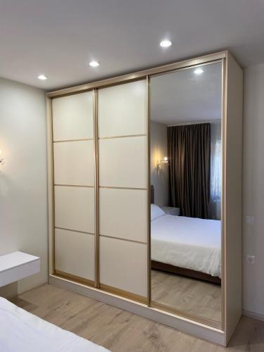 a bedroom with a large glass closet with a bed at Vivat in Berehove