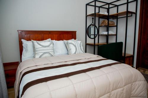 a bedroom with a large bed with white pillows at Be Home Apartments in Nkoanrua