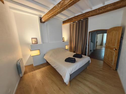 a bedroom with a bed with two black bags on it at Clair de Provence in Entrevennes