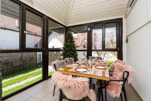 a dining room with a table and chairs and windows at Tudor Central House Sibiu - Garden, Parking, Quiet Area in Sibiu