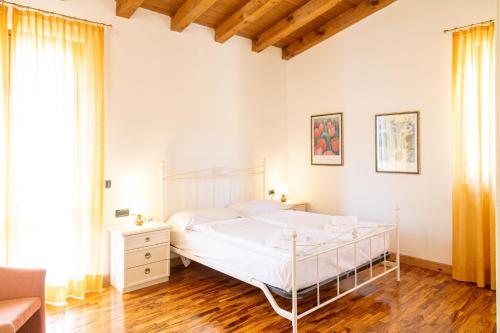 a white bedroom with a bed and a couch at Appartamenti Apollo XI, GTSGroup in Tignale