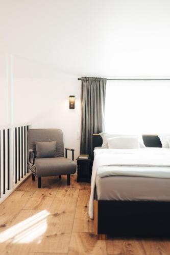 a bedroom with a bed and a chair at AMRAI Magnetic in Ventspils