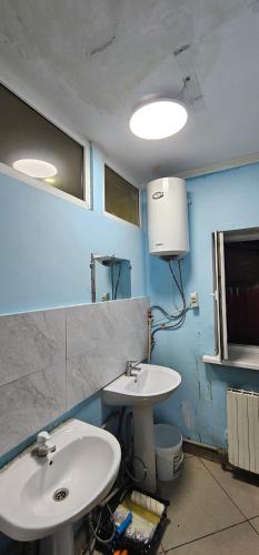 a bathroom with two sinks and a blue wall at Corps-A in Almaty